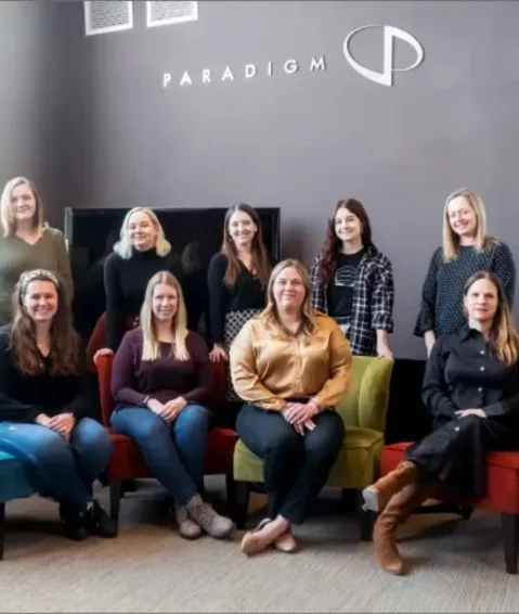 Nine of Paradigm's 10 female staff members pose for a Women's History Month photo.