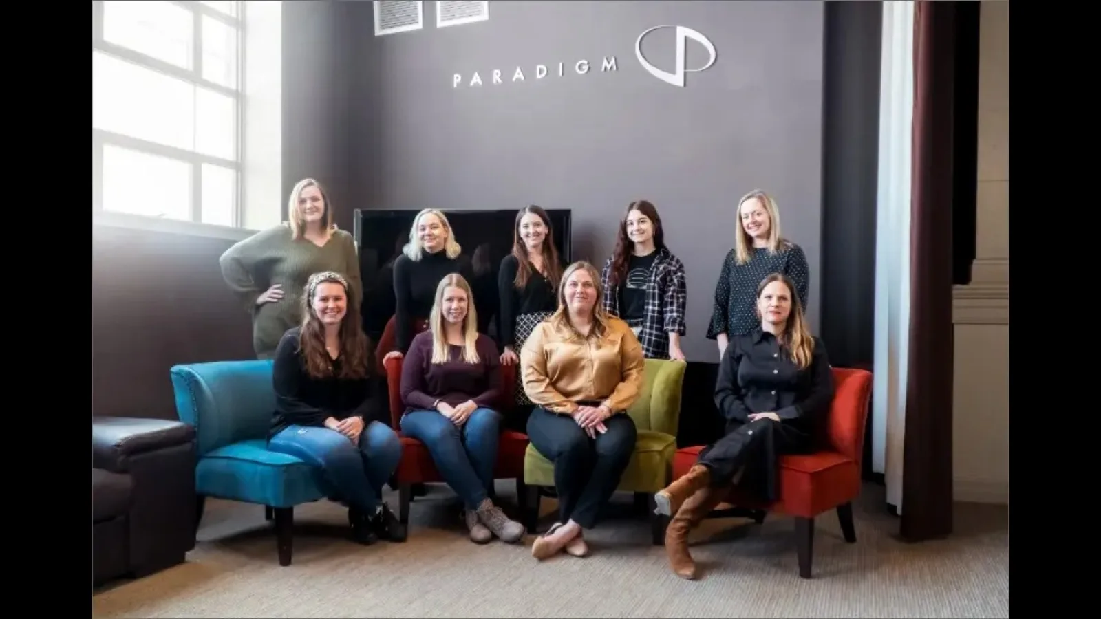 Nine of Paradigm's 10 female staff members pose for a Women's History Month photo.