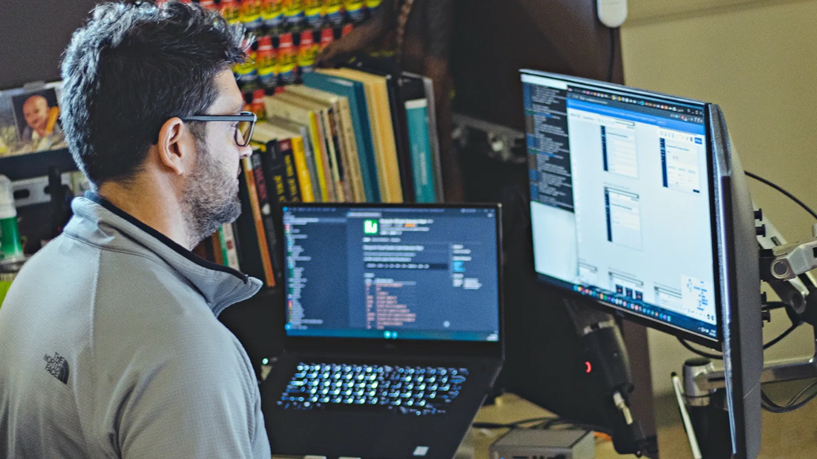 A man looking at a computer screen with code on it, alluding the development of types of AI.