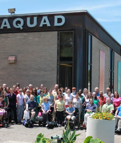 group of people posing in front of the Paraquad building