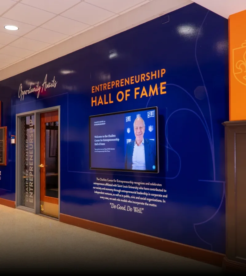 image of wall covered with branded graphics and a large touch screen tv.