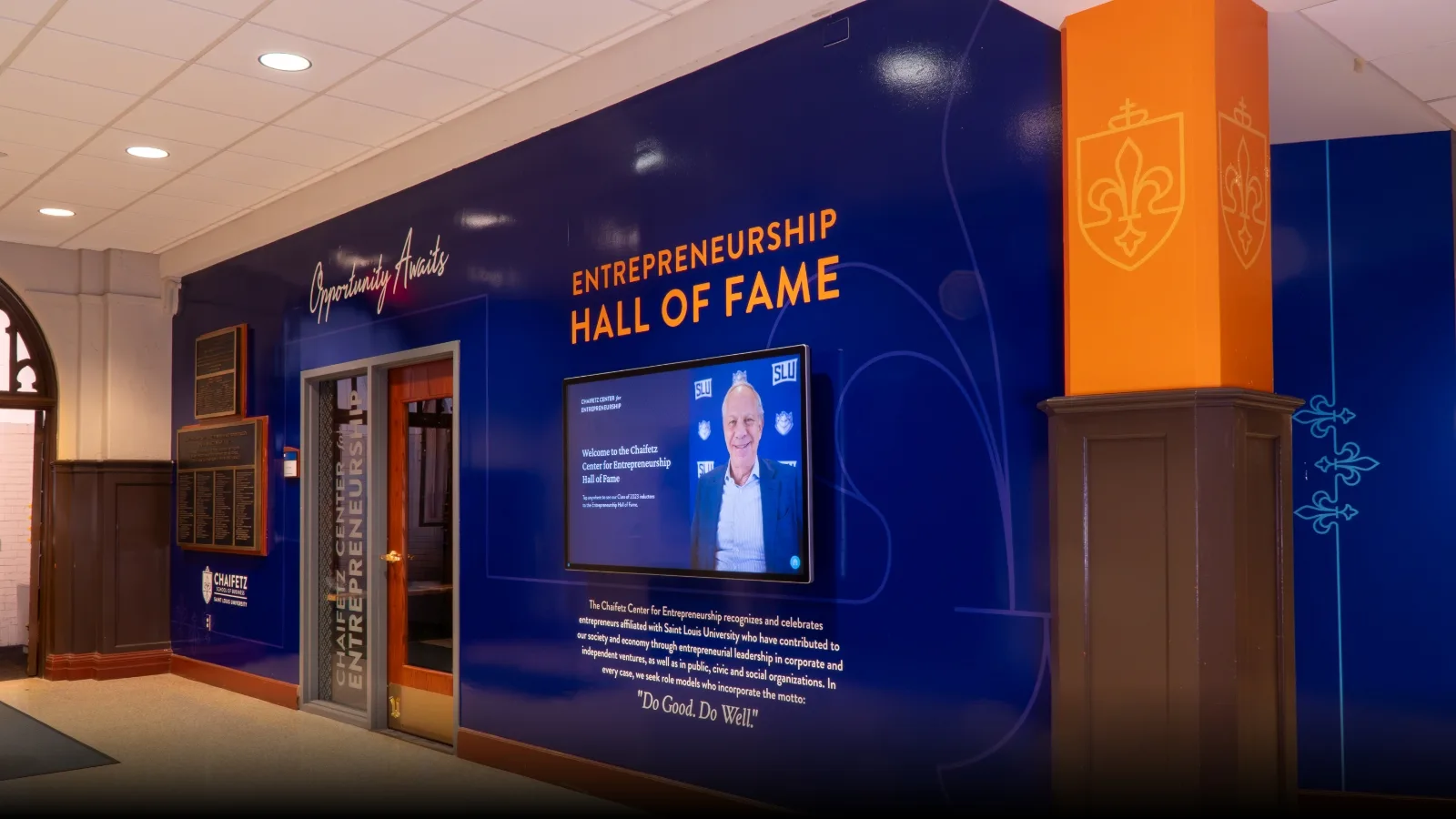 image of wall covered with branded graphics and a large touch screen tv.