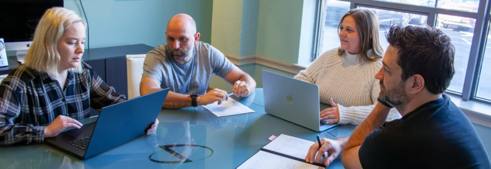 Paradigm team members meet in a board room.