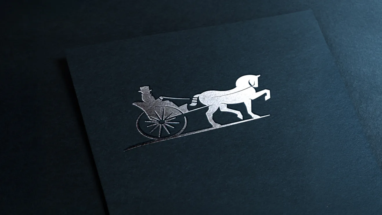 A metallic silver horse-and-carriage logo stamped on textured dark navy paper.
